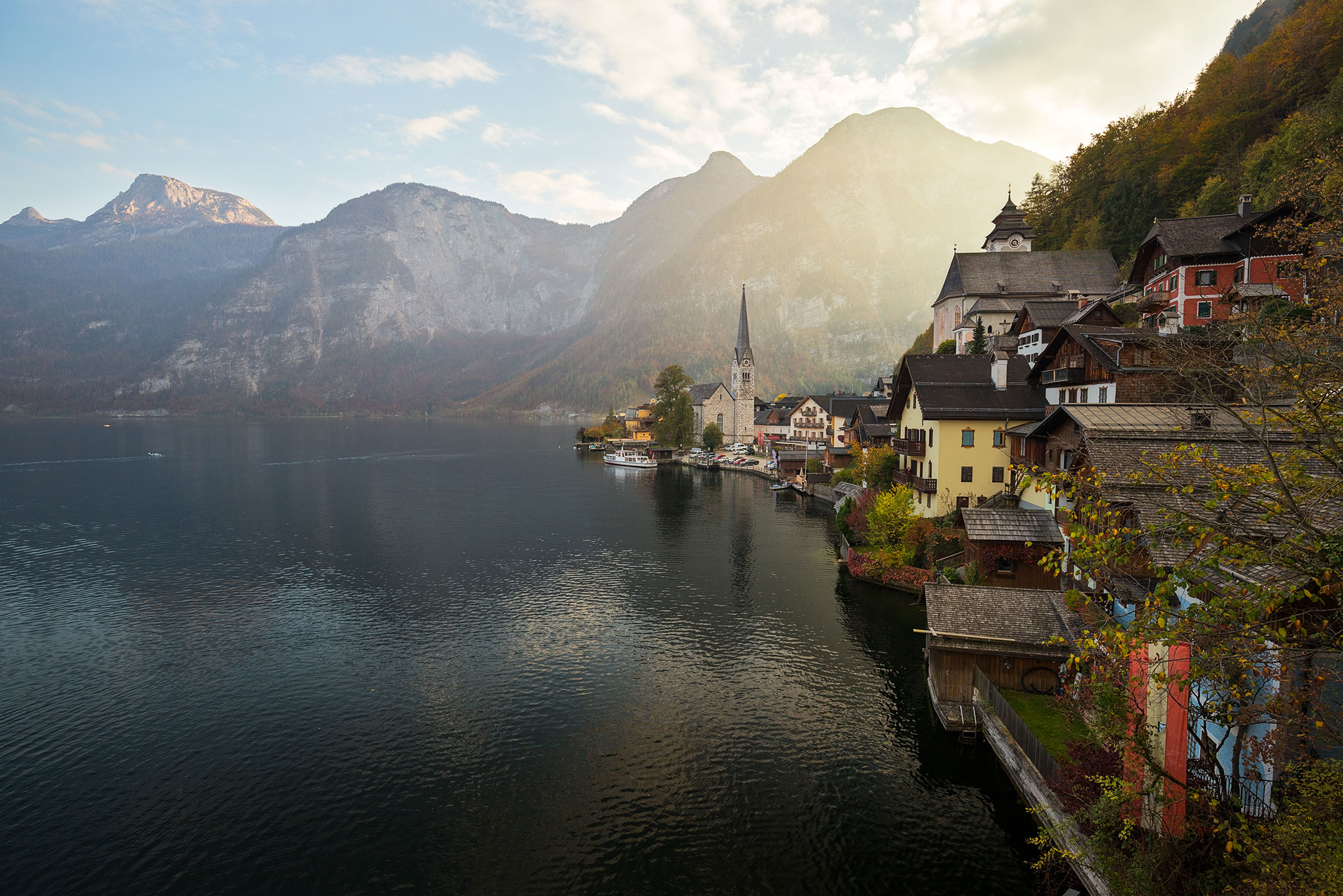 The late afternoon sun escapes from the valley behind Hallstatt, Austria