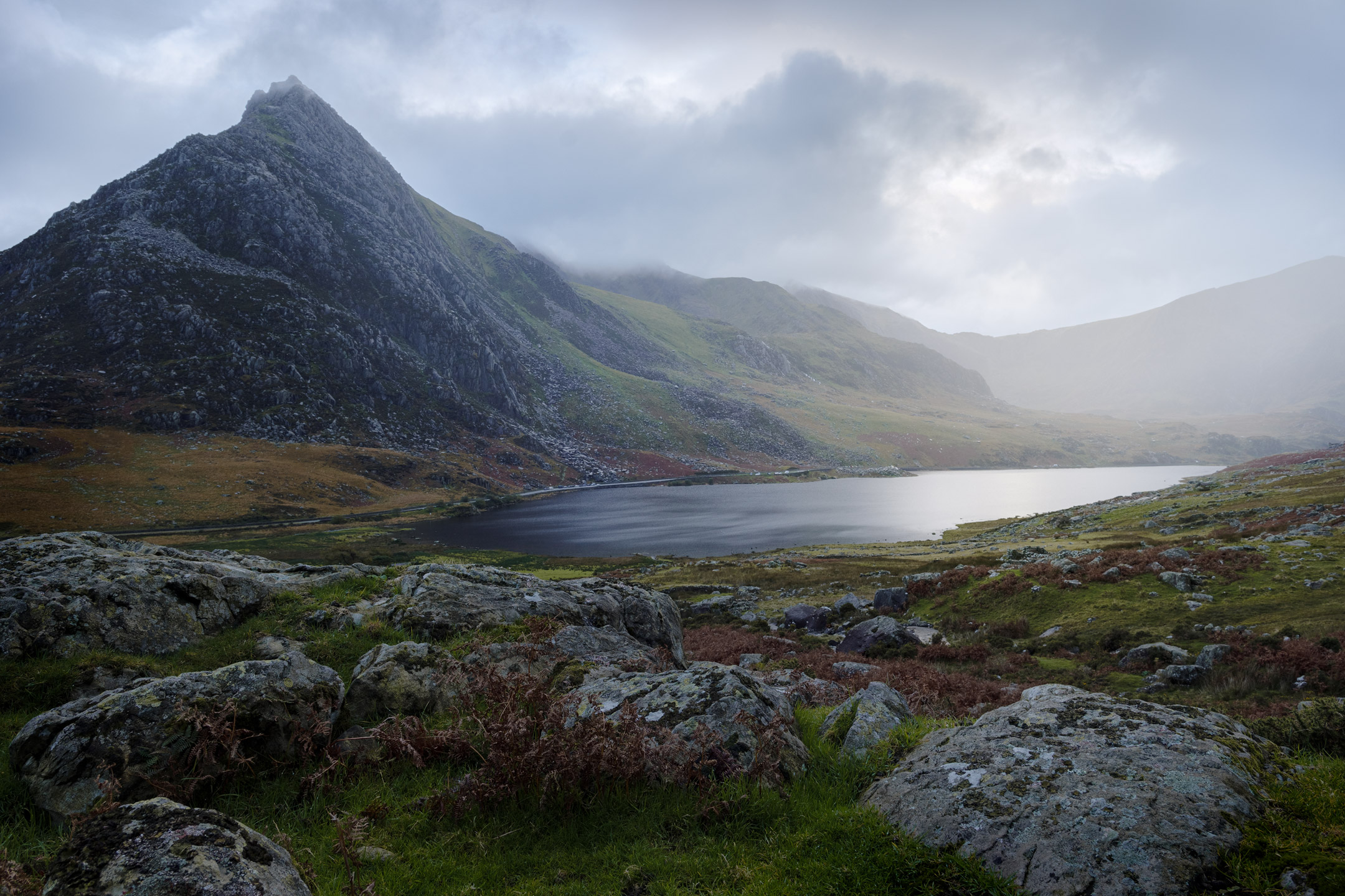 The looming peak of Tryfan broods over Llyn Ogwen in Snowdonia, Wales